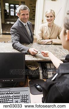 Stock Photo - couple paying 
at hotel front 
desk. fotosearch 
- search stock 
photos, pictures, 
images, and photo 
clipart