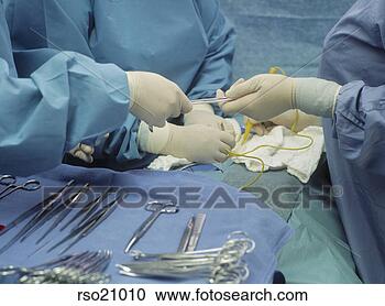 Stock Photography - doctors handling 
surgical equipment. 
fotosearch - search 
stock photos, 
pictures, images, 
and photo clipart