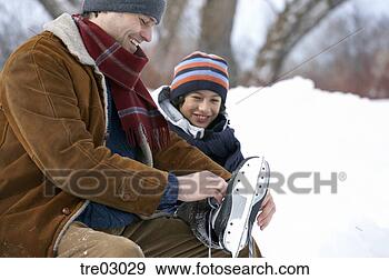 Stock Photograph - father helping 
son put on ice 
skates. fotosearch 
- search stock 
photos, pictures, 
images, and photo 
clipart