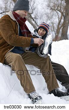 Stock Photography - father helping 
son put on ice 
skates. fotosearch 
- search stock 
photos, pictures, 
images, and photo 
clipart