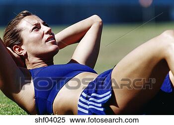 Stock Image - female athlete 
doing sit-ups 
on grass. fotosearch 
- search stock 
photos, pictures, 
images, and photo 
clipart