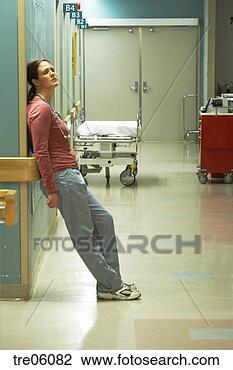 Stock Photo - female nurse leaning 
against corridor 
wall. fotosearch 
- search stock 
photos, pictures, 
images, and photo 
clipart