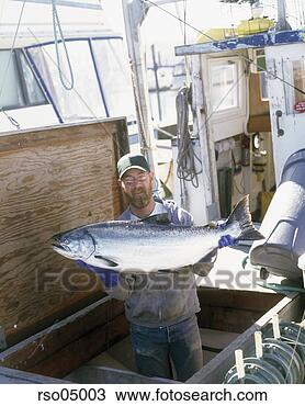 Stock Photo - fisherman holding 
large fish on 
boat. fotosearch 
- search stock 
photos, pictures, 
images, and photo 
clipart