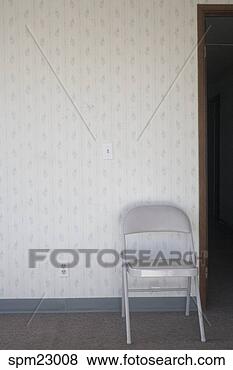 Stock Photo - folding chair 
against wall. 
fotosearch - search 
stock photos, 
pictures, images, 
and photo clipart