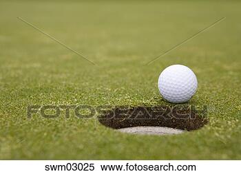 Stock Image - golf ball rolling 
towards hole. 
fotosearch - search 
stock photos, 
pictures, images, 
and photo clipart