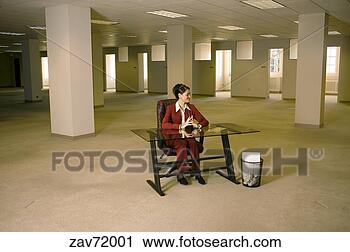 Stock Photography - hispanic businesswoman 
sitting at desk 
in empty office. 
fotosearch - search 
stock photos, 
pictures, images, 
and photo clipart