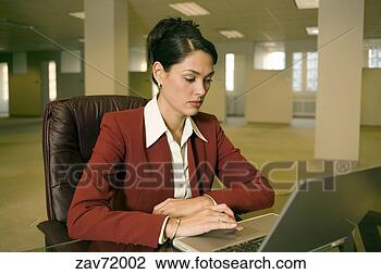 Stock Photo - hispanic businesswoman 
using laptop in 
empty office. 
fotosearch - search 
stock photos, 
pictures, images, 
and photo clipart