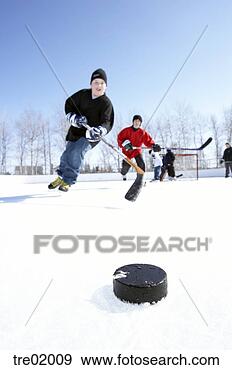 Stock Photograph - ice hockey player 
skating towards 
puck. fotosearch 
- search stock 
photos, pictures, 
images, and photo 
clipart