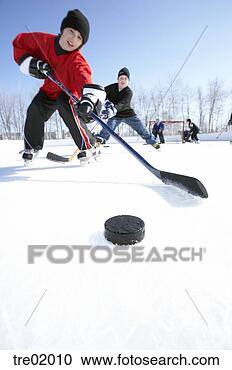 Stock Photography - ice hockey player 
skating towards 
puck. fotosearch 
- search stock 
photos, pictures, 
images, and photo 
clipart