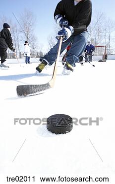 Stock Photography - ice hockey player 
skating towards 
puck. fotosearch 
- search stock 
photos, pictures, 
images, and photo 
clipart