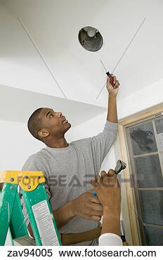 Stock Image - male carpenter 
changing a lightbulb. 
fotosearch - search 
stock photos, 
pictures, images, 
and photo clipart