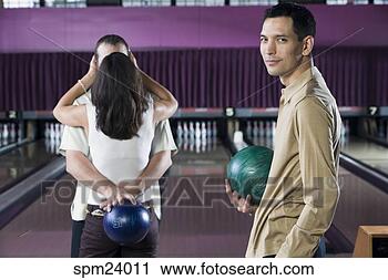 Stock Photography - man holding bowling 
ball and couple 
kissing in bowling 
alley. fotosearch 
- search stock 
photos, pictures, 
images, and photo 
clipart