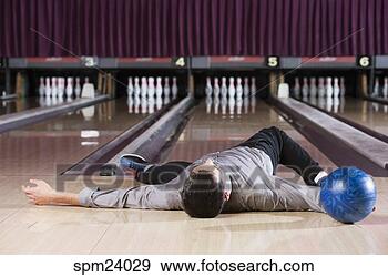 Stock Photograph - man laying with 
bowling ball in 
bowling alley. 
fotosearch - search 
stock photos, 
pictures, images, 
and photo clipart