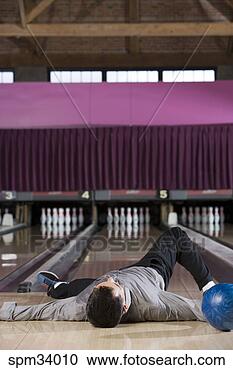 Stock Photography - man laying with 
bowling ball in 
bowling alley. 
fotosearch - search 
stock photos, 
pictures, images, 
and photo clipart