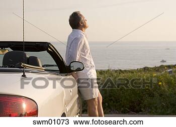 Stock Photo - man leaning on 
sports car. fotosearch 
- search stock 
photos, pictures, 
images, and photo 
clipart