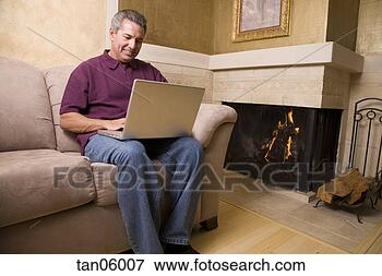 Picture - mature man using 
laptop in living 
room. fotosearch 
- search stock 
photos, pictures, 
images, and photo 
clipart