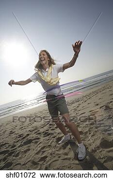 Stock Photo - mature woman with 
hula hoops on 
the beach. fotosearch 
- search stock 
photos, pictures, 
images, and photo 
clipart