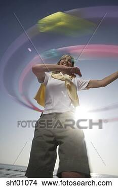 Stock Photo - mature woman with 
hula hoops on 
the beach. fotosearch 
- search stock 
photos, pictures, 
images, and photo 
clipart