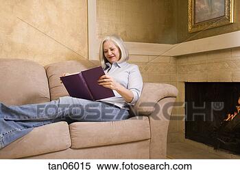Stock Image - mature woman reading 
in living room. 
fotosearch - search 
stock photos, 
pictures, images, 
and photo clipart