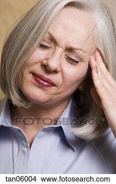 Stock Photo - mature woman rubbing 
her temple. fotosearch 
- search stock 
photos, pictures, 
images, and photo 
clipart