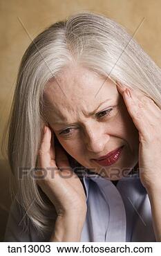 Stock Photo - mature woman rubbing 
her temple. fotosearch 
- search stock 
photos, pictures, 
images, and photo 
clipart
