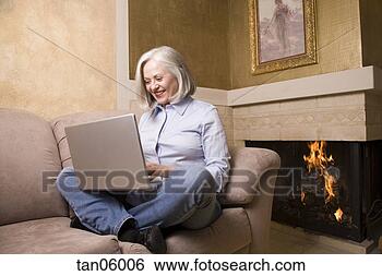 Stock Photo - mature woman using 
laptop in living 
room. fotosearch 
- search stock 
photos, pictures, 
images, and photo 
clipart