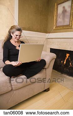 Stock Photo - mature woman using 
laptop in living 
room. fotosearch 
- search stock 
photos, pictures, 
images, and photo 
clipart