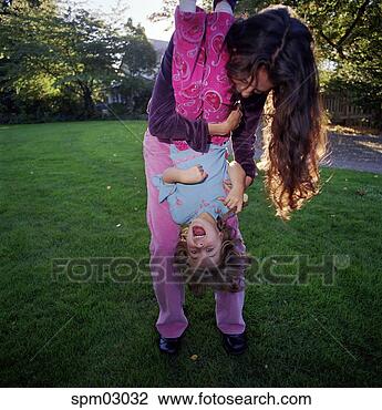 Stock Photo - mother holding 
daughter upside 
down. fotosearch 
- search stock 
photos, pictures, 
images, and photo 
clipart