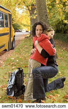 Stock Photography - mother hugging 
daughter by school 
bus. fotosearch 
- search stock 
photos, pictures, 
images, and photo 
clipart