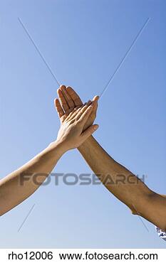 Stock Photo - people holding 
hands against 
blue sky. fotosearch 
- search stock 
photos, pictures, 
images, and photo 
clipart