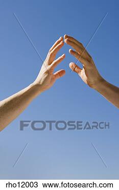 Stock Photo - people reaching 
hands against 
blue sky. fotosearch 
- search stock 
photos, pictures, 
images, and photo 
clipart