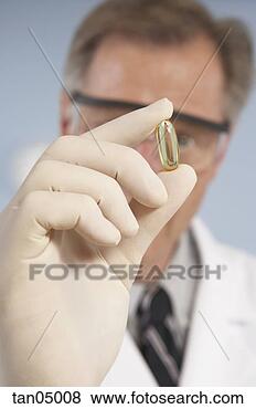 Stock Photo - scientist holding 
capsule. fotosearch 
- search stock 
photos, pictures, 
images, and photo 
clipart