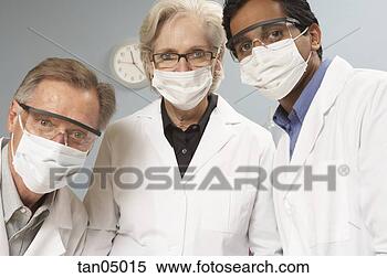 Stock Image - scientists wearing 
surgical masks 
and safety glasses. 
fotosearch - search 
stock photos, 
pictures, images, 
and photo clipart
