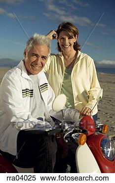 Stock Image - senior couple 
riding moped. 
fotosearch - search 
stock photos, 
pictures, images, 
and photo clipart