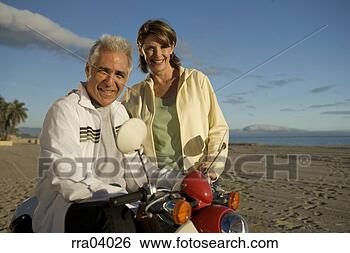 Stock Photo - senior couple 
riding moped. 
fotosearch - search 
stock photos, 
pictures, images, 
and photo clipart