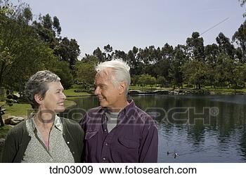 Stock Photograph - senior couple 
standing by pond. 
fotosearch - search 
stock photos, 
pictures, images, 
and photo clipart