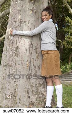 Stock Photo - teenage african 
girl smiling and 
hugging tree. 
fotosearch - search 
stock photos, 
pictures, images, 
and photo clipart
