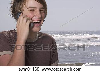 Stock Photo - teenage boy talking 
on cell phone 
at beach. fotosearch 
- search stock 
photos, pictures, 
images, and photo 
clipart
