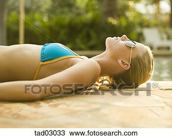 Stock Photo - teenage girl in 
bikini sunbathing 
next to swimming 
pool. fotosearch 
- search stock 
photos, pictures, 
images, and photo 
clipart