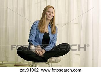Stock Photo - teenage girl sitting 
cross-legged on 
stool. fotosearch 
- search stock 
photos, pictures, 
images, and photo 
clipart