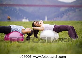 Stock Photo - two women exercising 
outdoors with 
exercise balls 
on grass. fotosearch 
- search stock 
photos, pictures, 
images, and photo 
clipart