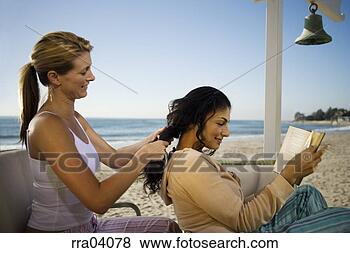 Stock Photo - woman braiding 
friend's hair 
on beach. fotosearch 
- search stock 
photos, pictures, 
images, and photo 
clipart