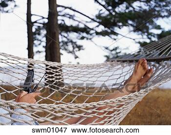Picture - woman with cell 
phone relaxing 
in hammock. fotosearch 
- search stock 
photos, pictures, 
images, and photo 
clipart