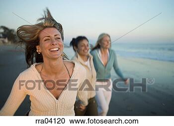 Stock Photography - woman running 
ahead of friends 
at beach. fotosearch 
- search stock 
photos, pictures, 
images, and photo 
clipart