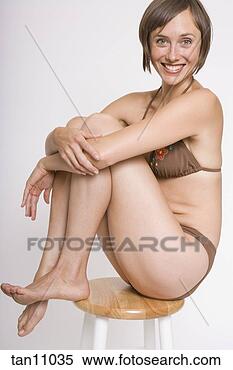 Stock Image - woman sitting 
on stool in bikini. 
fotosearch - search 
stock photos, 
pictures, images, 
and photo clipart