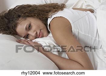 Stock Photo - woman smiling 
in bed. fotosearch 
- search stock 
photos, pictures, 
images, and photo 
clipart