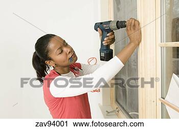 Stock Photography - woman using a 
power drill on 
windowsill. fotosearch 
- search stock 
photos, pictures, 
images, and photo 
clipart