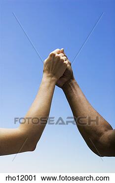 Stock Photography - women holding 
hands against 
blue sky. fotosearch 
- search stock 
photos, pictures, 
images, and photo 
clipart