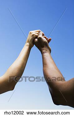 Stock Photo - women holding 
hands against 
blue sky. fotosearch 
- search stock 
photos, pictures, 
images, and photo 
clipart