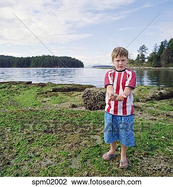 Stock Photo - young boy holding 
rock by river. 
fotosearch - search 
stock photos, 
pictures, images, 
and photo clipart